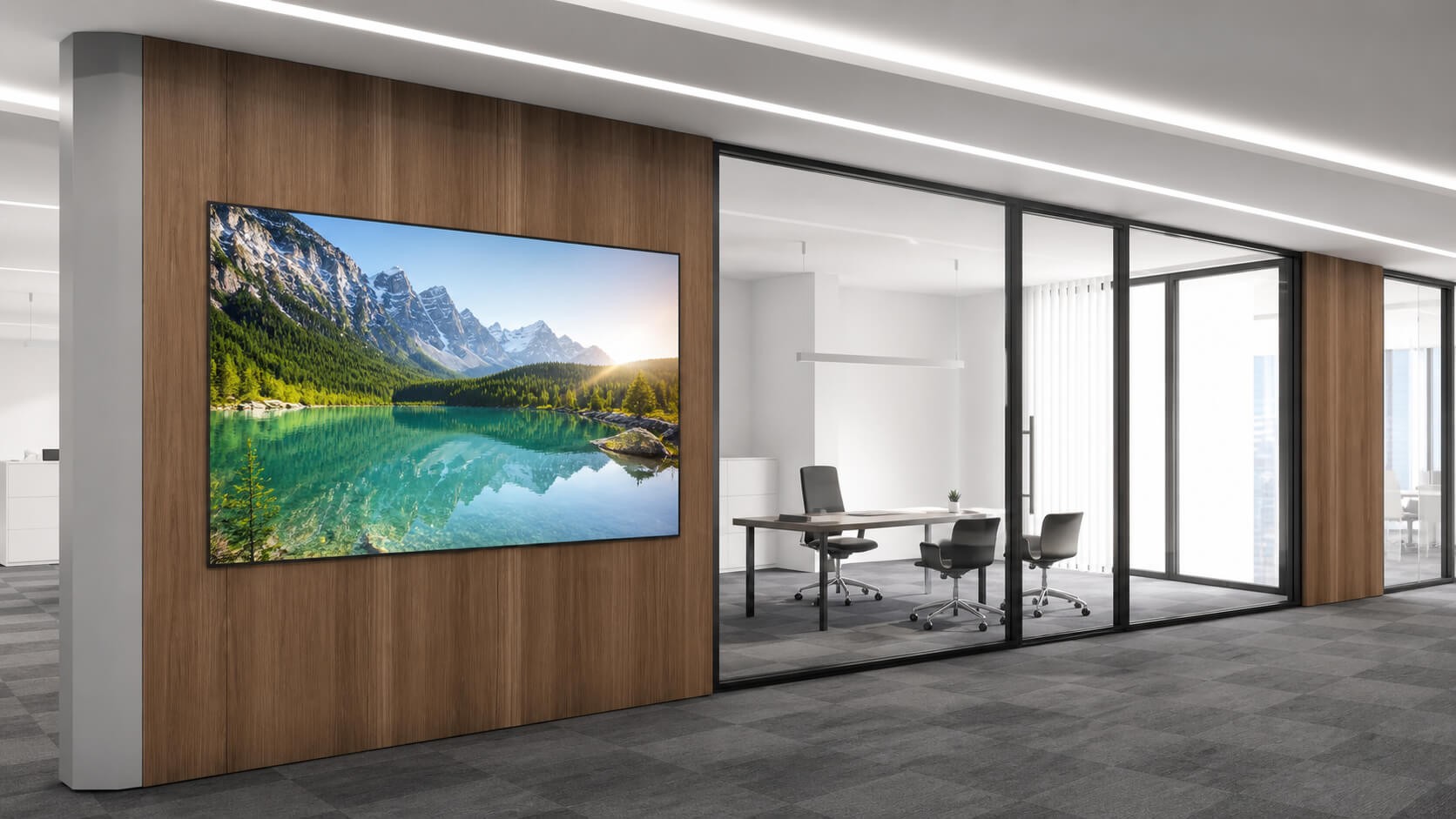 Wall-mounted OLED display showing an alpine lake in a minimalist modern office