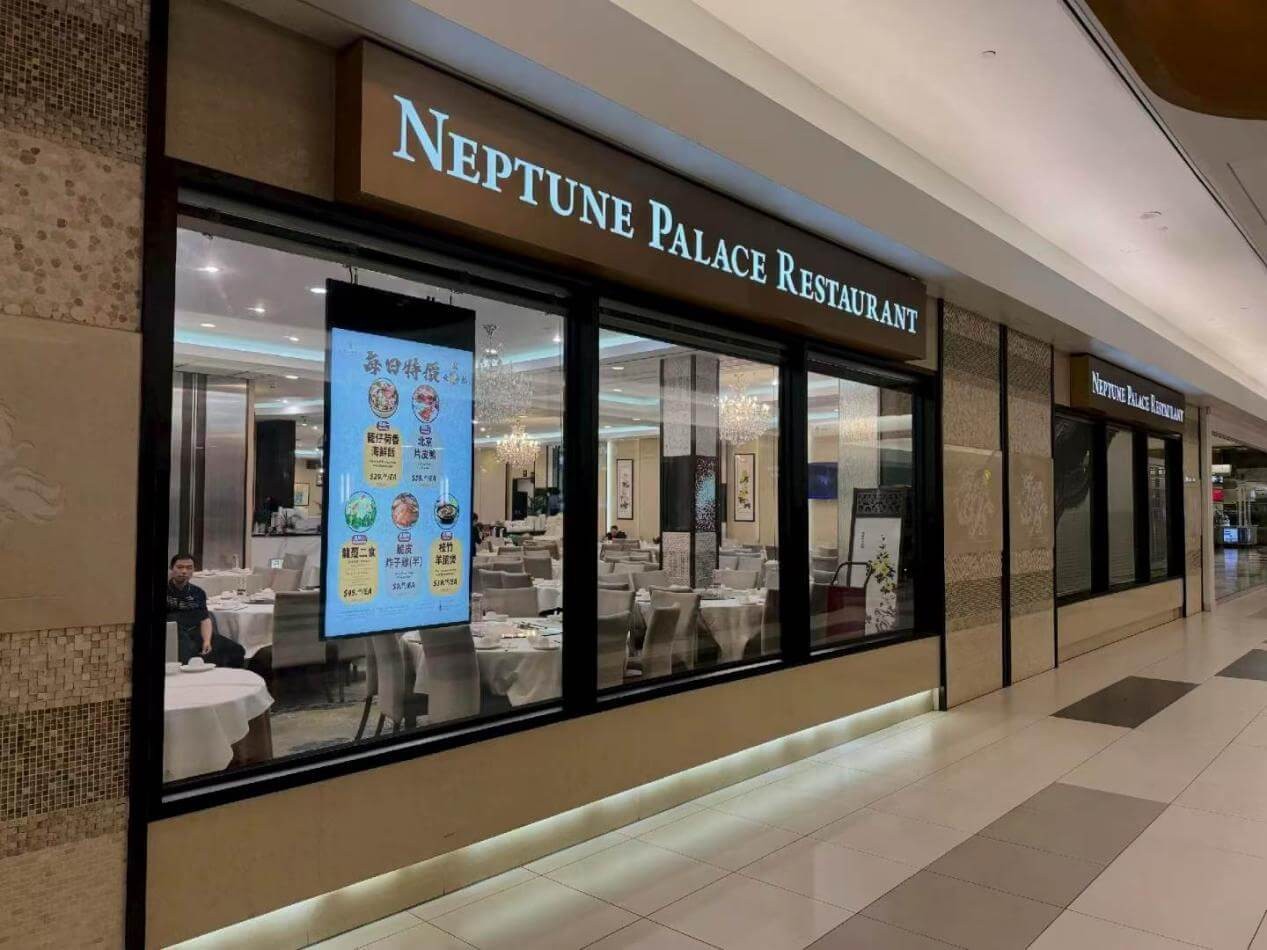 Ceiling-hung window-facing digital signage at Neptune Palace Restaurant in Canada
