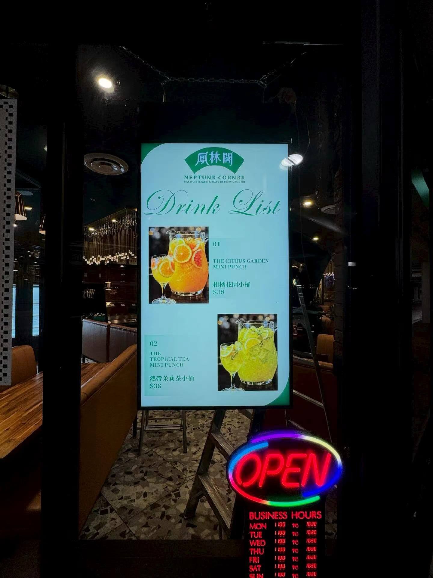 High-brightness restaurant drink menu displayed through storefront glass